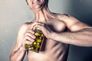Man straining to open a pickle jar. Courtesy of gratisography.com