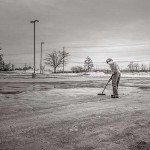 A solitary individual sweeping an empty parking lot. Courtesy of gratisography.com