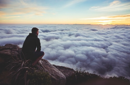 Man seeing the big picture over the clouds