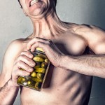 Man straining to open a pickle jar. Courtesy of gratisography.com