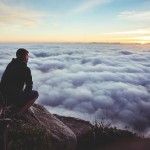 Man seeing the big picture over the clouds, courtesy of unsplash.com